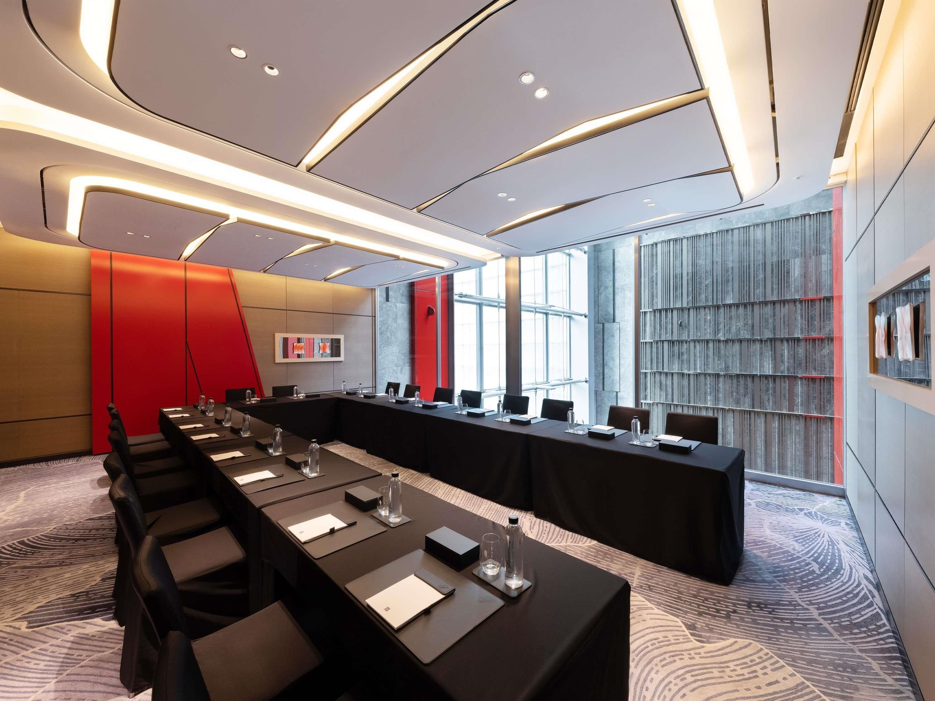 A conference room with a long table, chairs, and a large window.