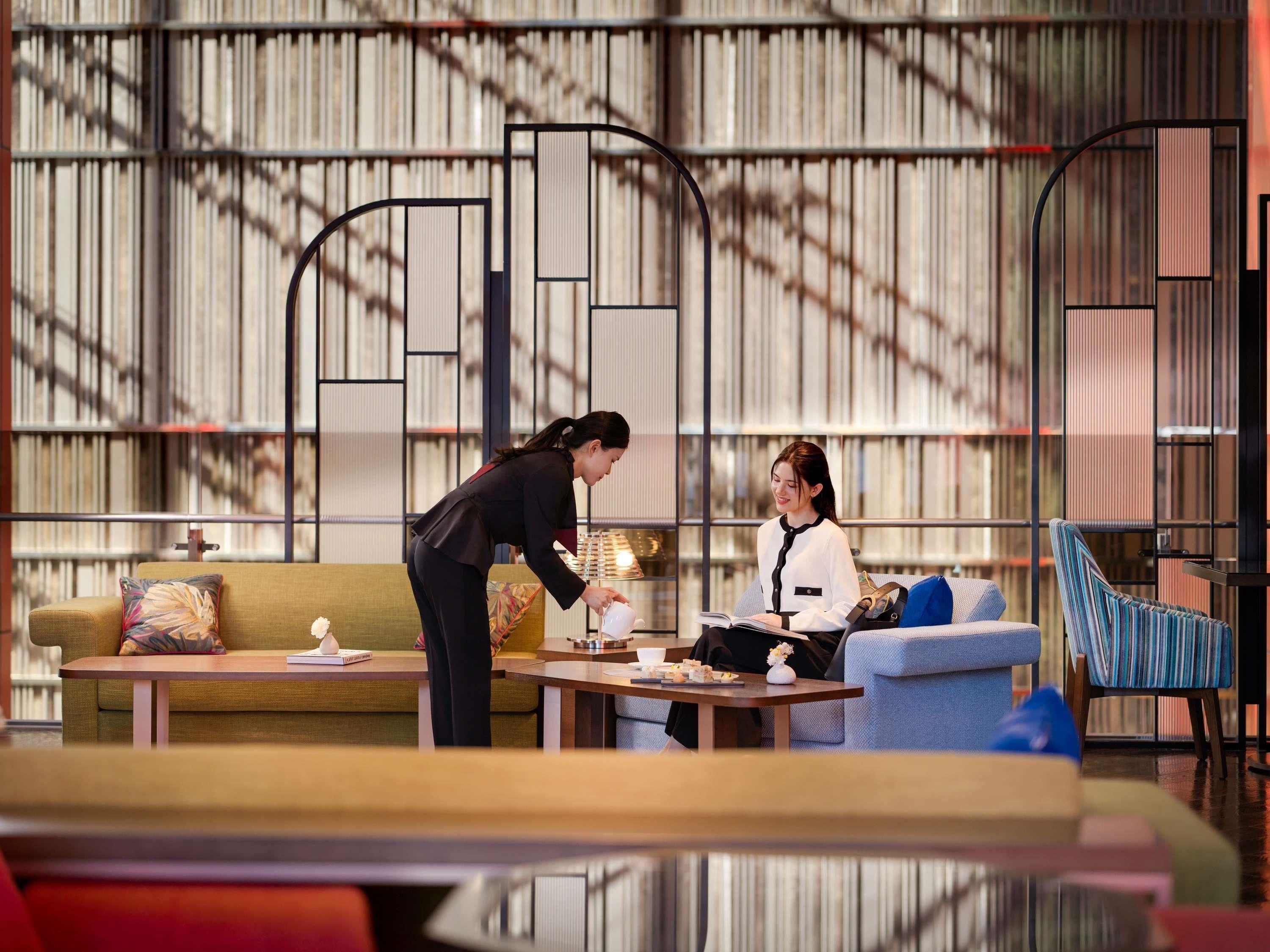 A modern interior with a sofa, a table, and a bookshelf in the background.
