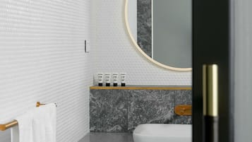 A bathroom with a marble sink, a towel rack, and a mirror with a gold frame.