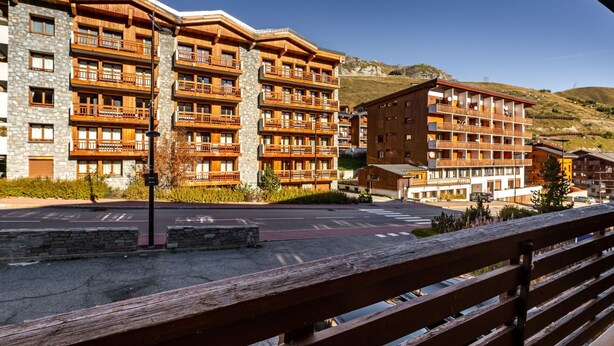 Un hôtel à plusieurs étages, doté de balcons, d’une façade en pierre et situé dans un cadre vallonné.