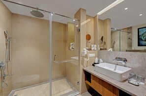 A modern bathroom with a glass-enclosed shower, a large sink, and a vanity with a mirror. - The Fern Leo Resort & Club Junagadh (Junagadh)