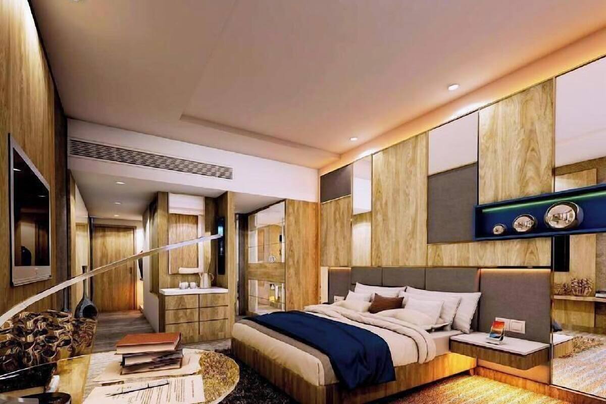 Ein modernes Hotelzimmer mit einem großen Bett, einem Schreibtisch, einem Stuhl und einem Fernseher.