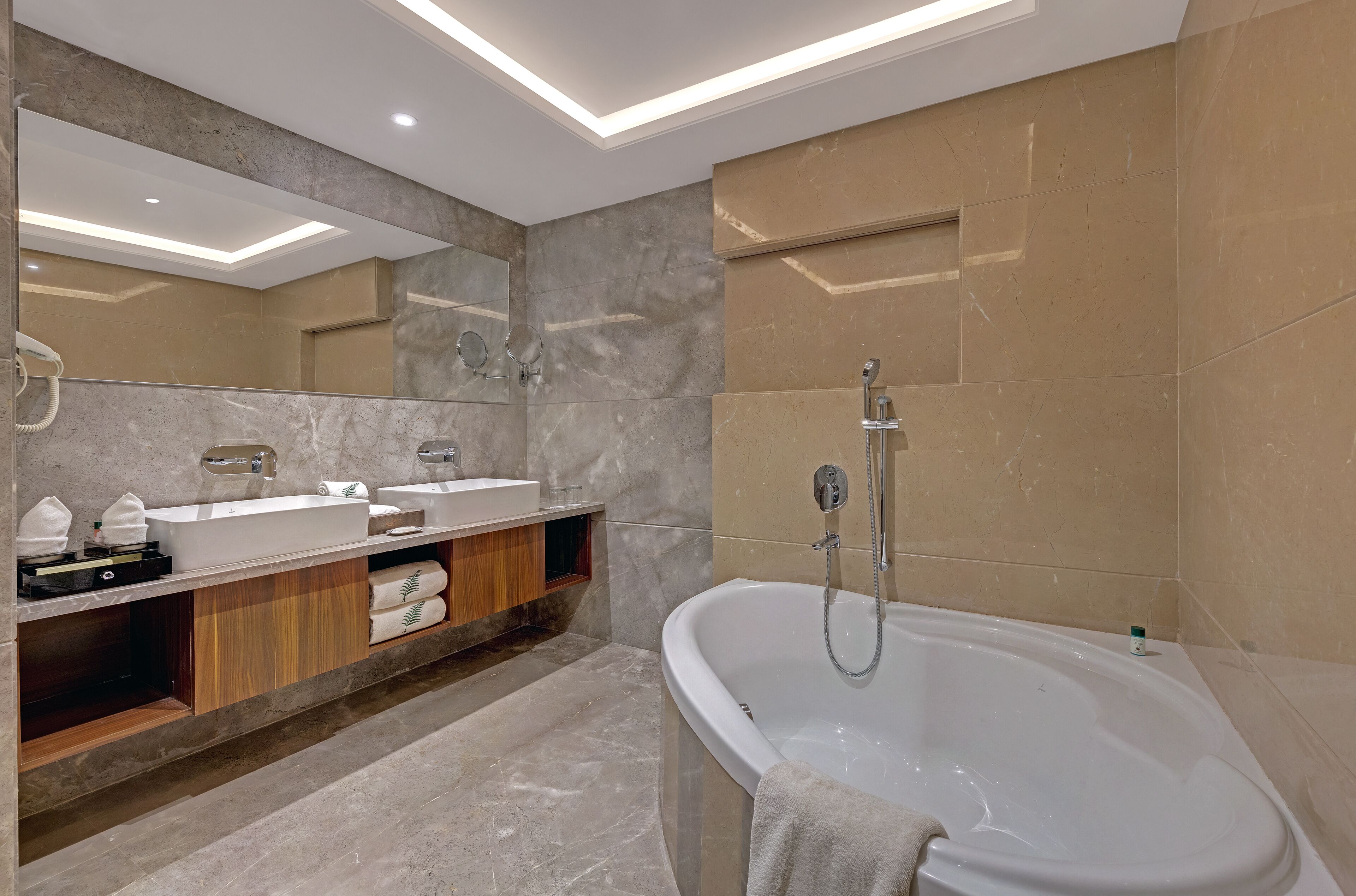 A modern bathroom with a freestanding bathtub, a vanity with a mirror, and a shower area.
