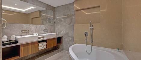 A modern bathroom with a freestanding bathtub, a vanity with a mirror, and a shower area.