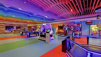 An indoor arcade with various gaming machines, including a hockey game and a racing game.