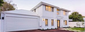 Un immeuble résidentiel à deux étages, doté d’un garage, d’une porte d’entrée et d’une allée.