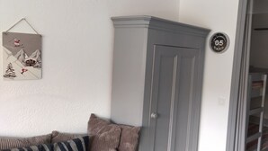 Ein Zimmer mit einem grauen Kleiderschrank, einer Wanduhr und einem gerahmten Bild eines Skifahrers.