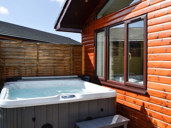 Un jacuzzi en una cabaña de madera con ventana.