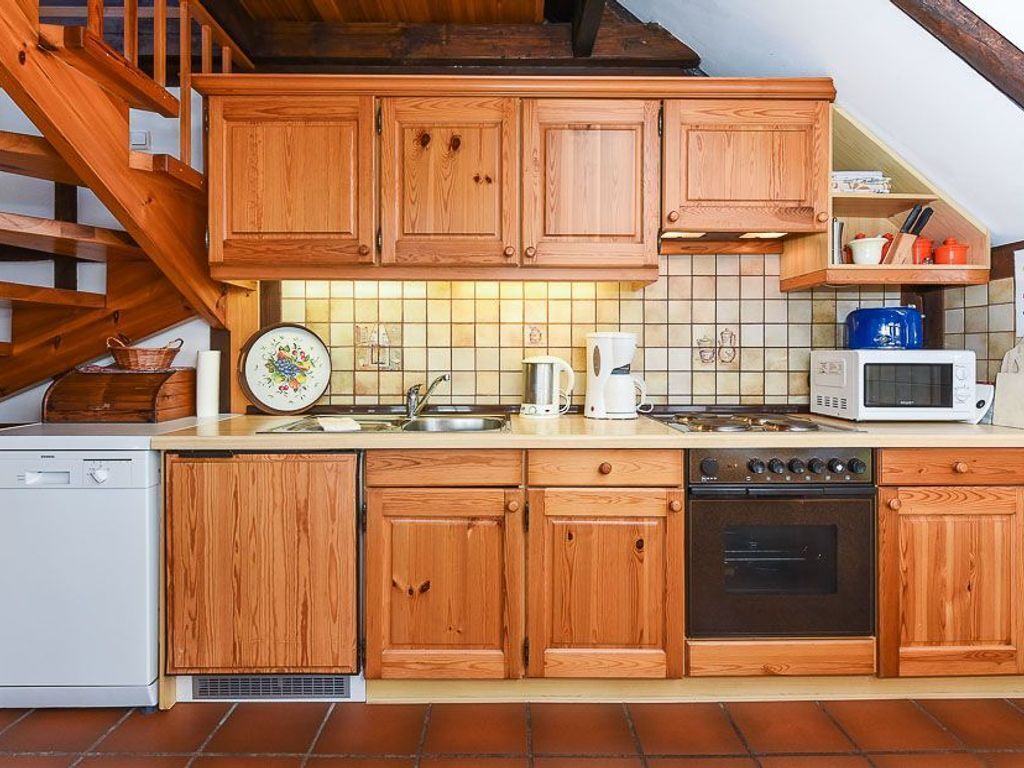 A kitchen with wooden cabinets, a microwave, a stove, and a dishwasher.