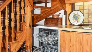 Een houten trap met een vaatwasser en een decoratief bord op een aanrecht.