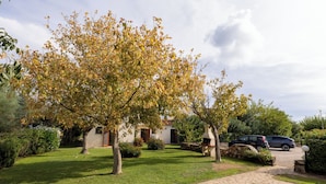 A well-maintained garden with a stone pathway leading to a house with a chimney. - Le Dimore di Budoni (Budoni)