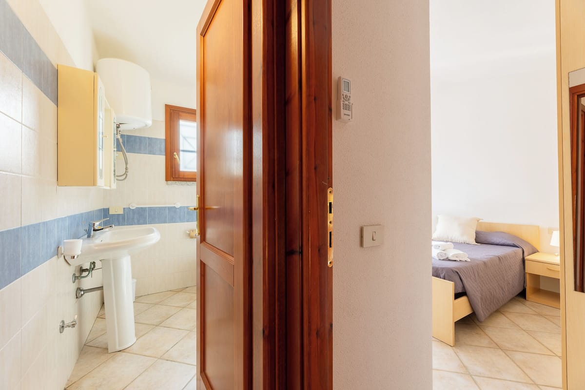 Un baño con lavamanos, espejo e inodoro.