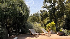 Une piscine aux eaux cristallines, dotée d’une terrasse en bois et de chaises longues.