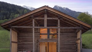 A log cabin with a balcony, a dining area, and a lounge with a view of the mountains. - Chalet 'Ferienhaus Im Stadl' with Mountain Views, Private Terrace and Wi-Fi (St. Martin in Passeier)
