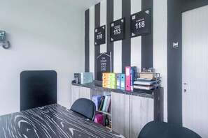 A room with a desk, chairs, a bookshelf, and a wall with numbered signs. - Life 2837 Apartment Dramaga Tower (Dramaga)