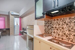 A kitchen with a microwave, stove, and tiled backsplash. - Life 2837 Apartment Dramaga Tower (Dramaga)