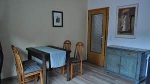 A dining area with a table, chairs, and a cabinet.