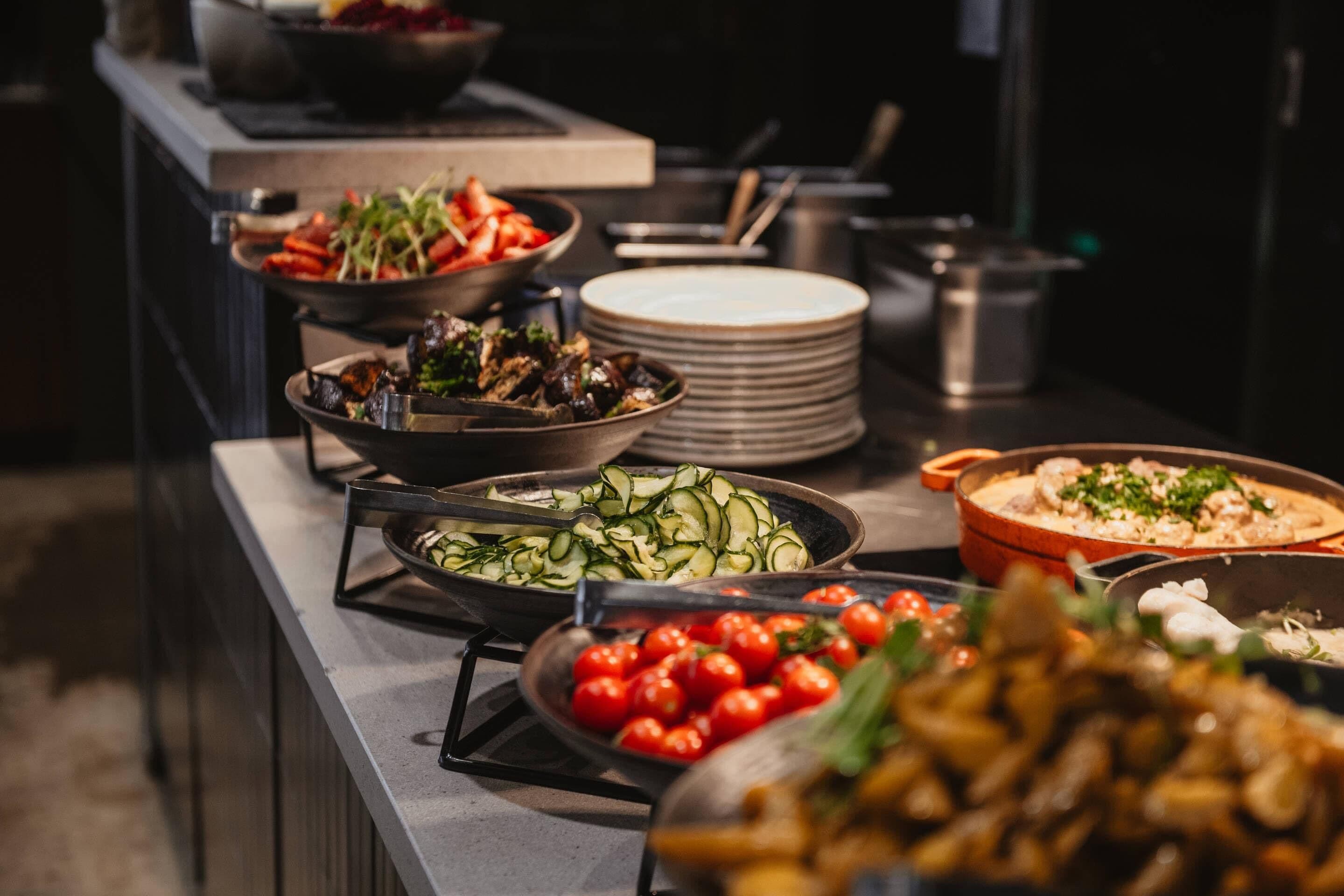 Buffet-pöydässä on tarjolla monenlaisia ruokia, kuten kasviksia, mereneläviä ja pastaa.