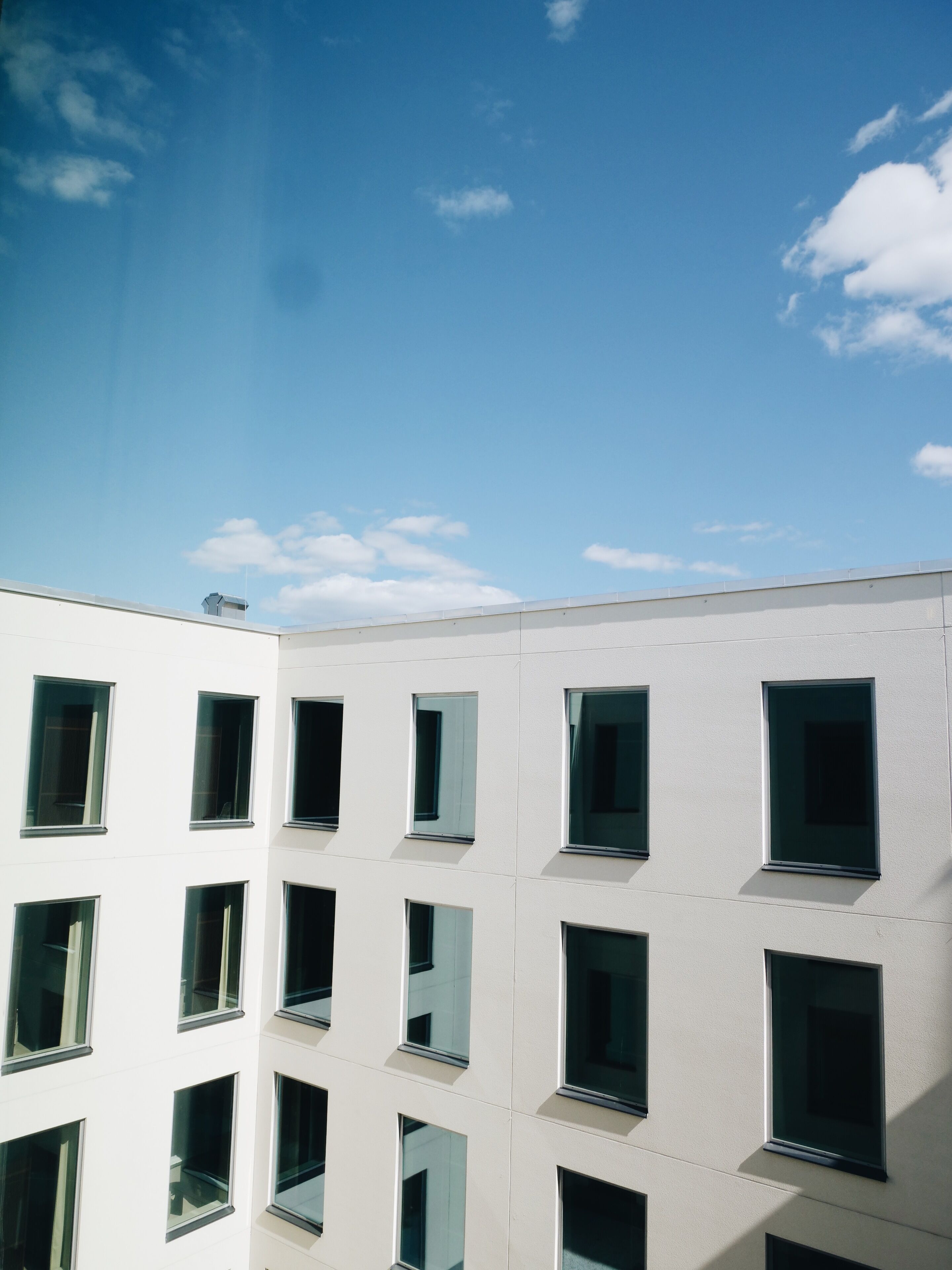 Un bâtiment moderne doté de nombreuses fenêtres et surplombant un ciel dégagé.