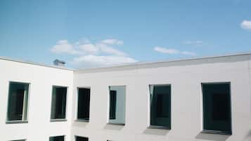 Un bâtiment moderne doté de nombreuses fenêtres et surplombant un ciel dégagé.