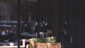 A buffet setup with various dishes, a wooden crate, and hanging pendant lights.
