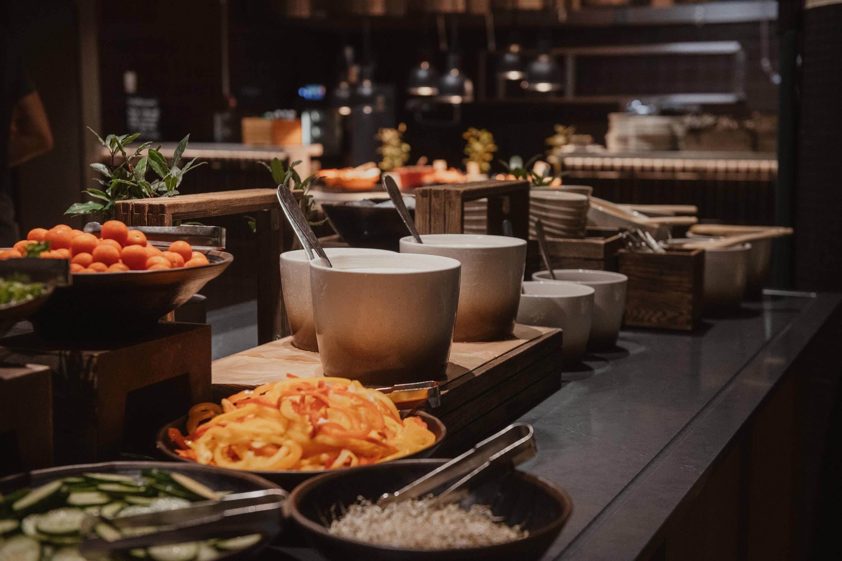 A buffet setup with various food items and utensils.
