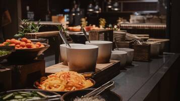 A buffet setup with various food items and utensils.