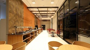A modern restaurant with a long counter, wooden chairs, and a patterned wall. - Comfort Suites Sao Jose do Rio Preto (São José do Rio Preto)