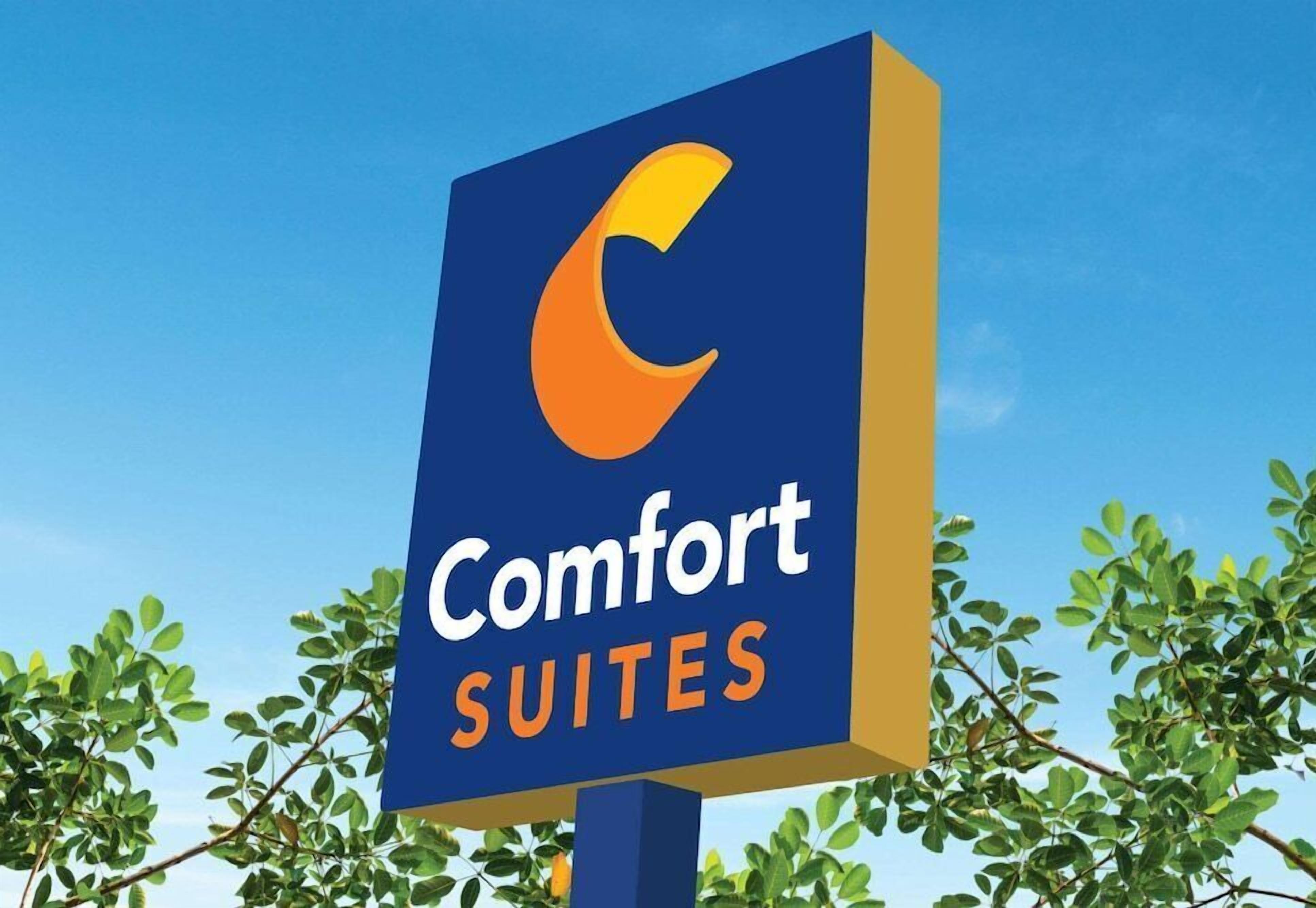 Señal de Comfort Suites, con logotipo estilizado de 'C'.