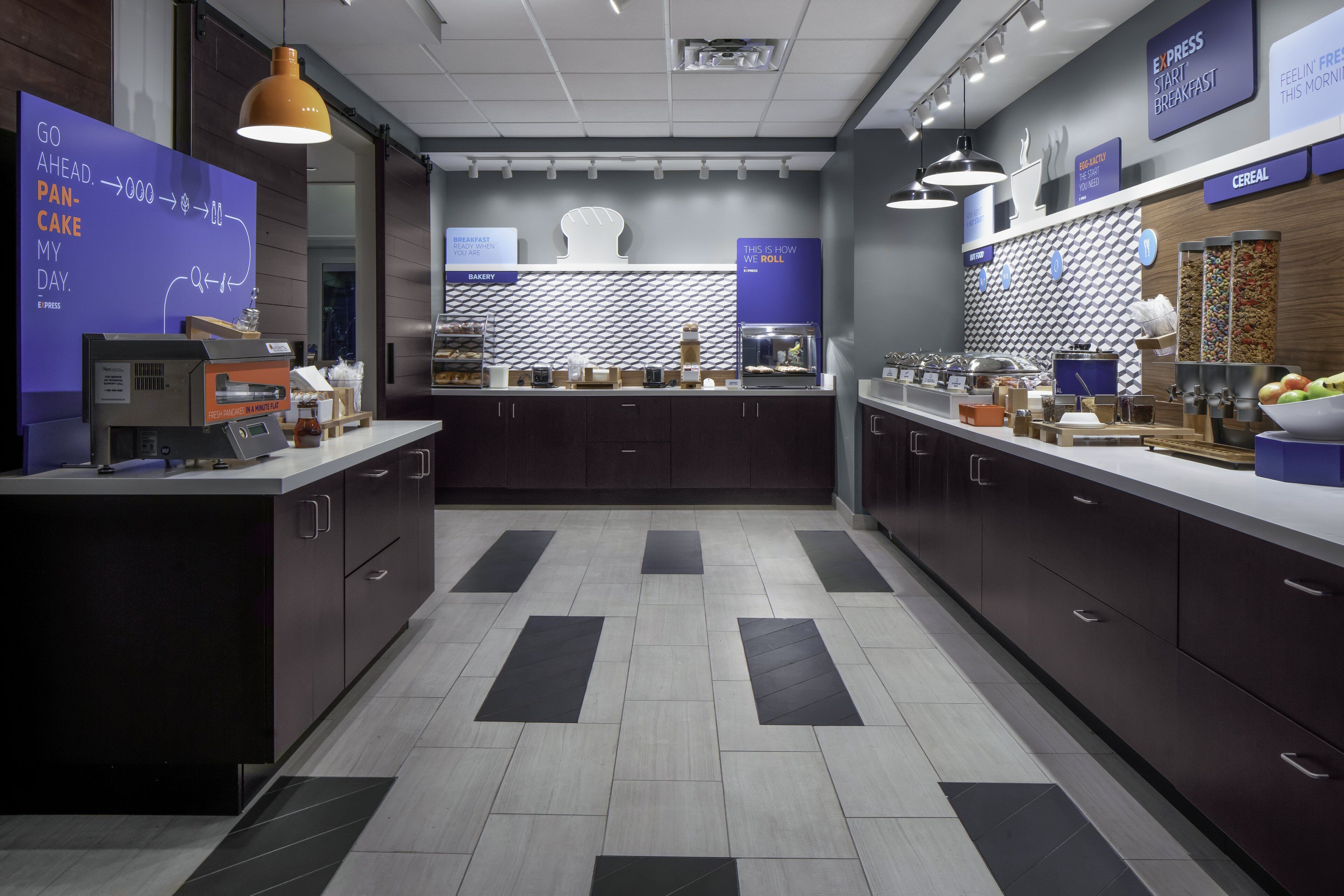 A modern kitchen with a central island, a bakery section, and a cereal display.
