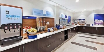 Una cocina moderna con una barra de frutas, dispensador de bebidas y una cafetera.