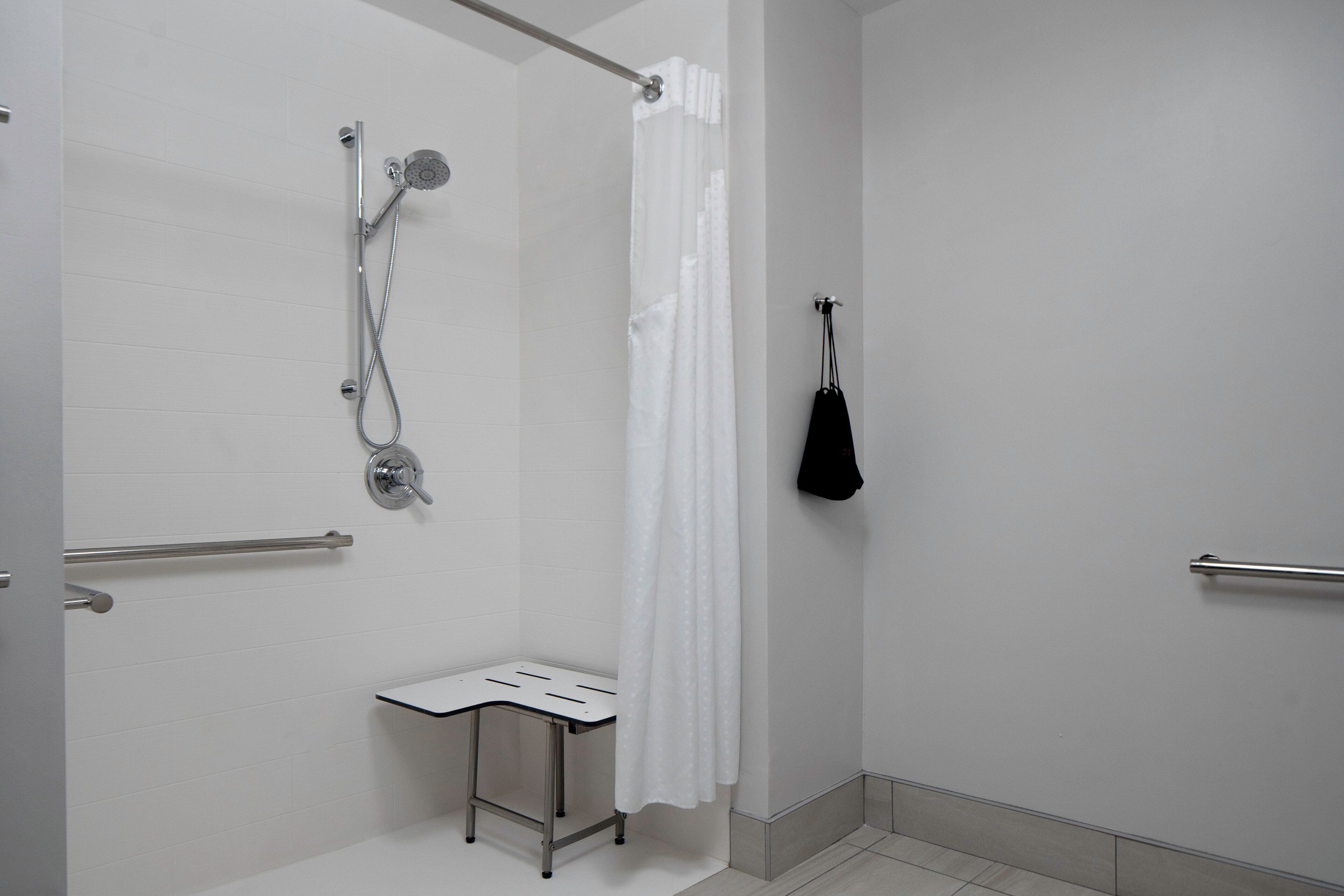 Un bagno con doccia, un portasciugamani e un piccolo tavolo.