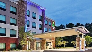 A multi-story hotel with a covered entrance and a visible sign for a nearby restaurant. - Holiday Inn Express and Suites Griffin by IHG (Griffin)
