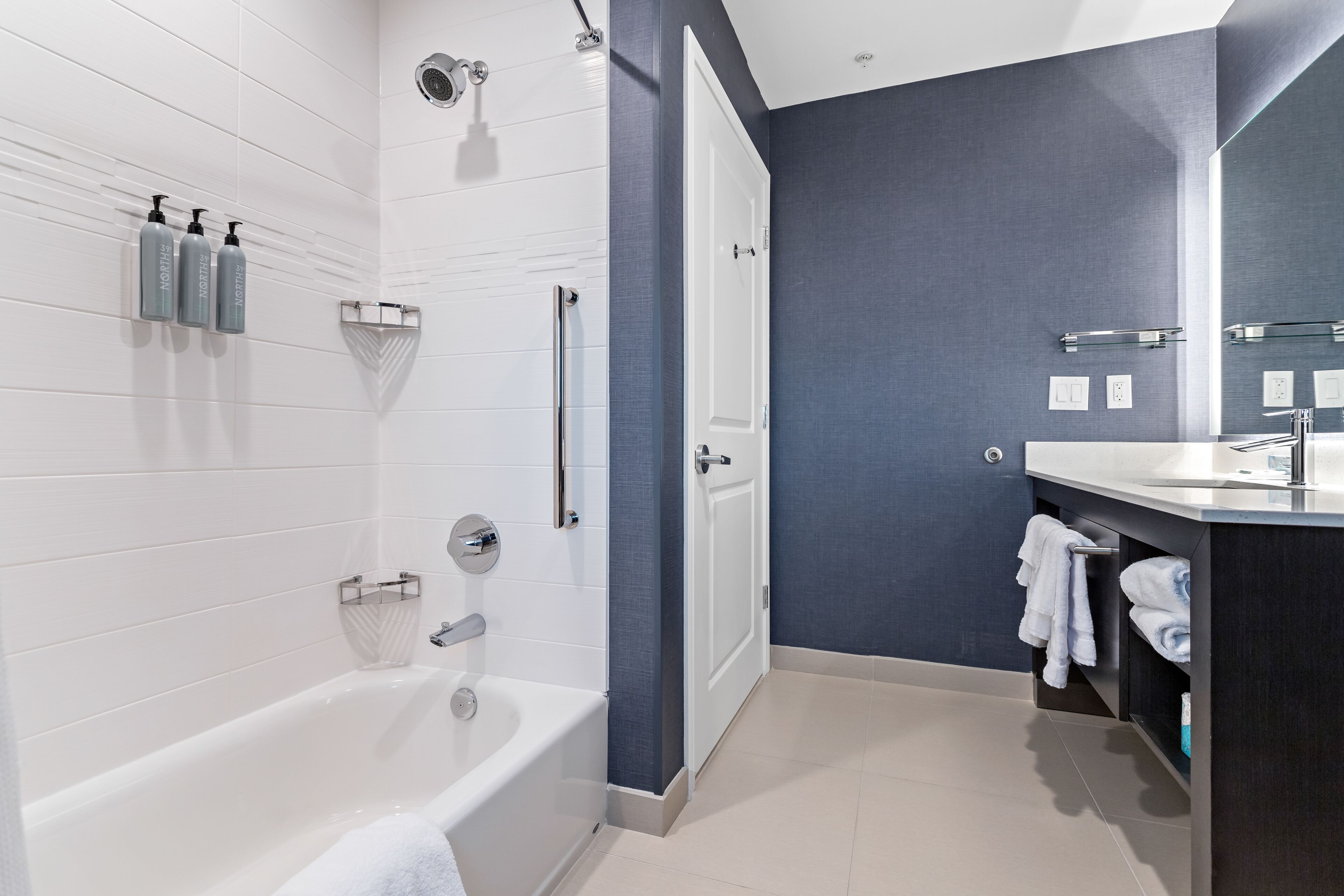 Une salle de bain moderne avec une baignoire, une douche et un meuble-lavabo.