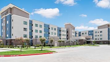 A multi-story hotel with a modern design, featuring a flat roof and a mix of blue and beige exterior colors.