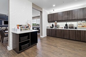 A modern kitchen with wooden cabinets, a white countertop, and a coffee machine. - Residence Inn by Marriott Port Arthur (Port Arthur)