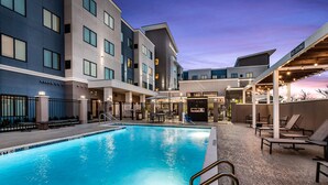 A swimming pool with a no diving sign, outdoor seating, and a building with multiple floors and windows. - Residence Inn by Marriott Port Arthur (Port Arthur)