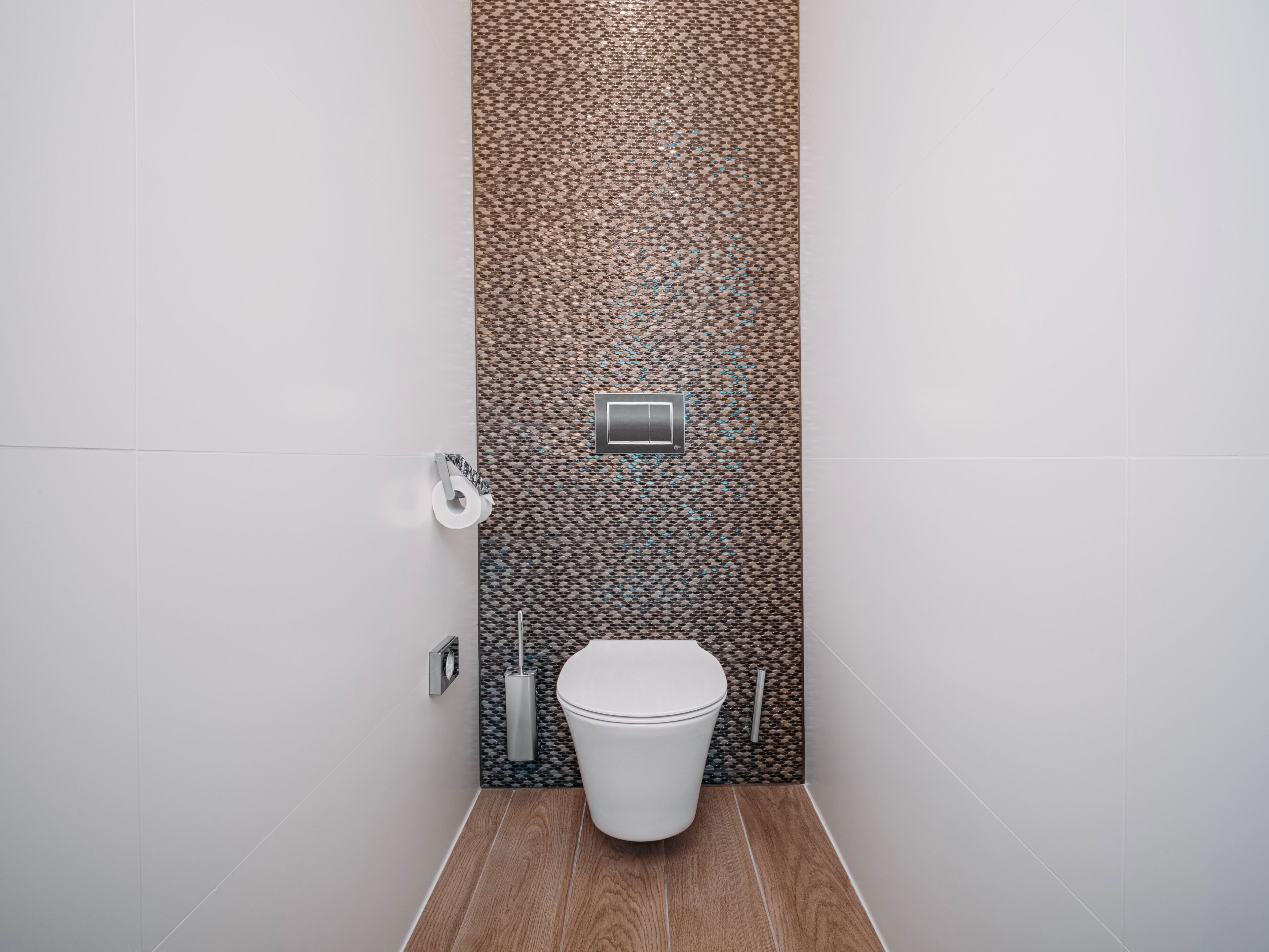 Ein modernes Badezimmer mit Toilette, strukturierter Wand und Holzboden.