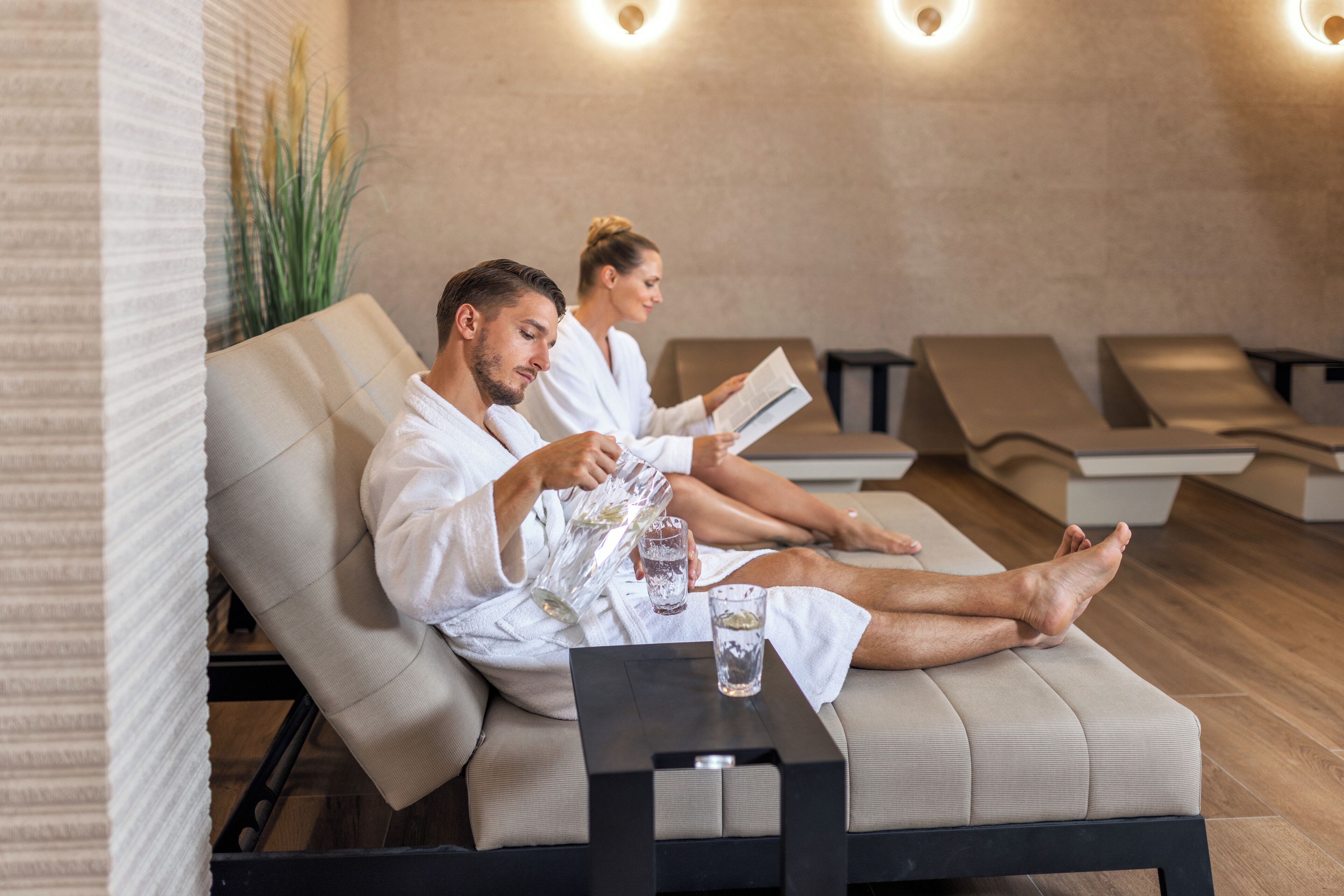 A spa area with reclining chairs and a small table with a glass of water.