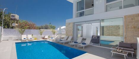 Alberca al aire libre y camastros