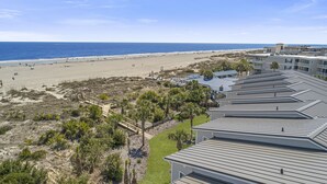A beachfront property with a boardwalk leading to the beach, a pool area, and ocean views. - Oceanfront Townhome w/ Pools, Pet-Friendly, Beach Access Right Out Back Door (Tybee Island)