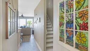 A hallway with a staircase, a kitchen area, and a dining space. - Oceanfront Townhome w/ Pools, Pet-Friendly, Beach Access Right Out Back Door (Tybee Island)