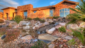 A hotel with a stone facade, a waterfall feature, and a sign reading "Coral Springs". - Zions Gateway Escape (Hurricane)