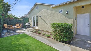 A house with a patio, outdoor seating, and a garage.