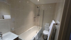 Un baño moderno con bañera, inodoro y lavamanos.