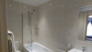 Un baño moderno con bañera, inodoro y lavamanos.