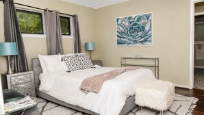 A bedroom with a bed, bedside tables, a lamp, a rug, and a painting on the wall. - Family Ready Spacious Retreat - 4BR, Sleeps 8, Pet Friendly with Gazebo (Houston)