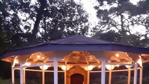 A gazebo with a stone fireplace, outdoor seating, and string lights. - Family Ready Spacious Retreat - 4BR, Sleeps 8, Pet Friendly with Gazebo (Houston)