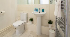 A modern bathroom with a toilet, sink, and towel rack.
