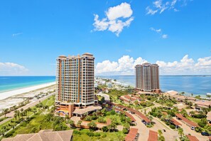 A resort with two high-rise buildings, a beach, and a marina.